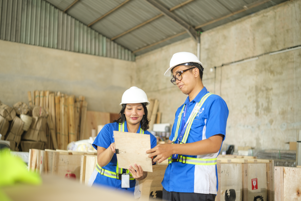 Two Jalak Kargo staff discussing a shipment in the warehouse