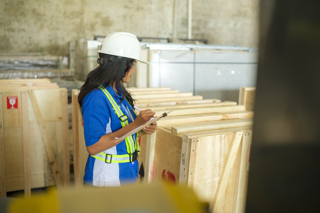 Warehouse staff checking export crates against a packing list in Bali